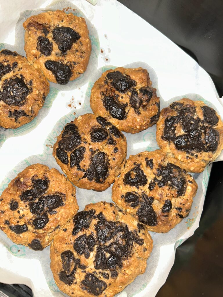 Freshly baked oatmeal chocolate chip cookies recipe stacked on a plate, with melted chocolate chips and golden-brown edges.