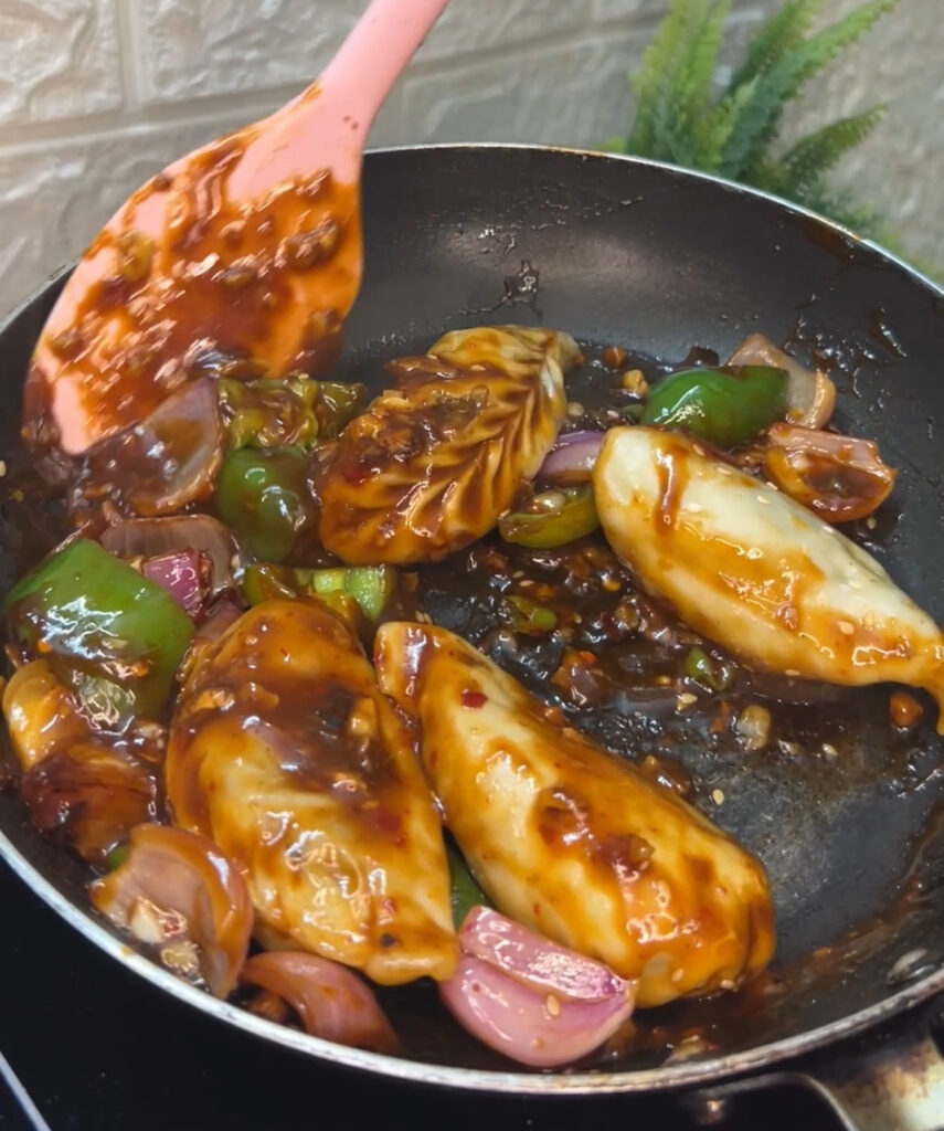 Close-up shot of spicy chili dumplings garnished with green onions