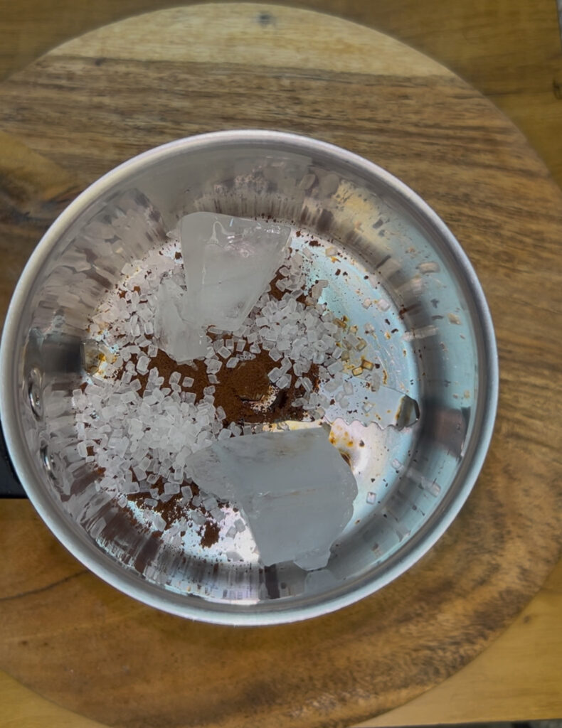 Top view of creamy iced coffee with whipped cream in a mason jar