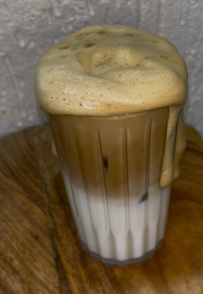 Cold brew iced coffee with coffee beans and mint garnish