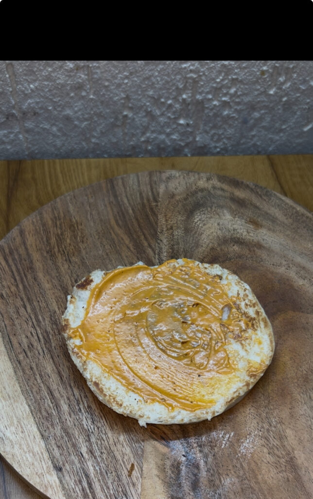 Grilled chicken burger served with crispy fries on a rustic wooden plate
