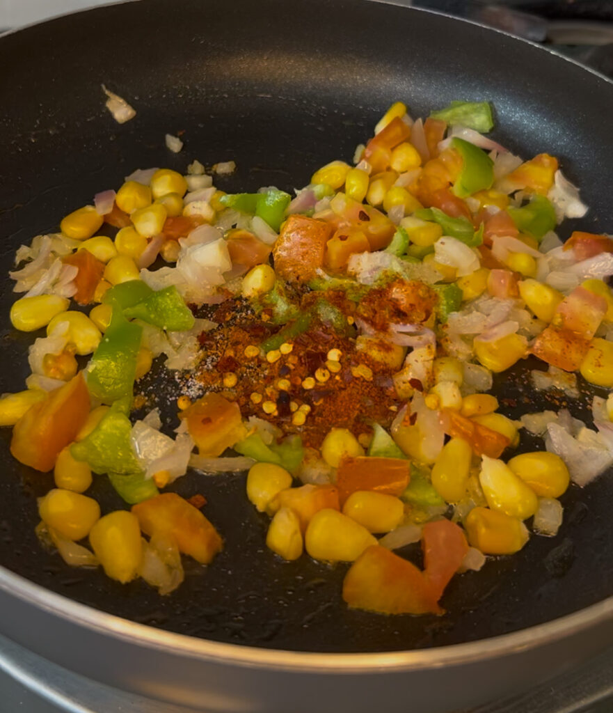 Preparation shot of cheesy vegetable buns being filled with veggies and cheese