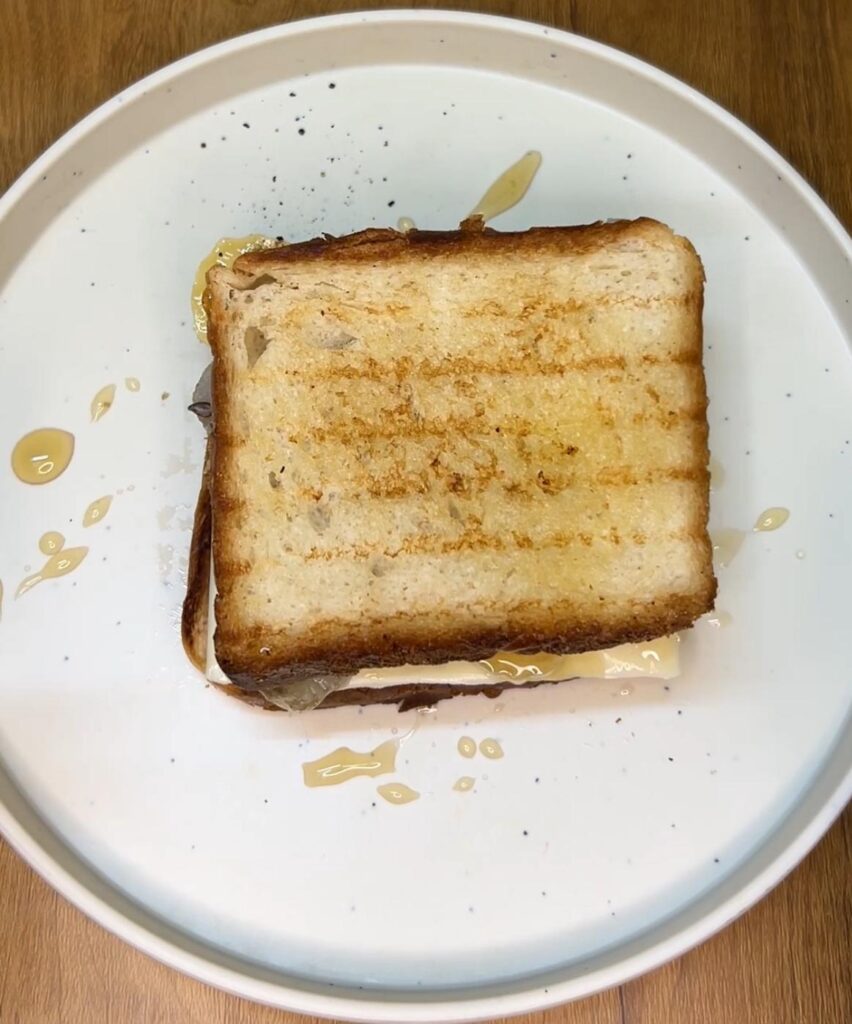 Healthy honey banana sandwich served with a side of fresh berries