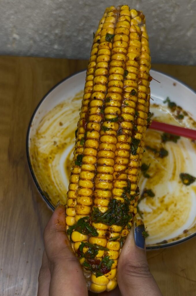 Close-up of juicy air fryer corn garnished with herbs