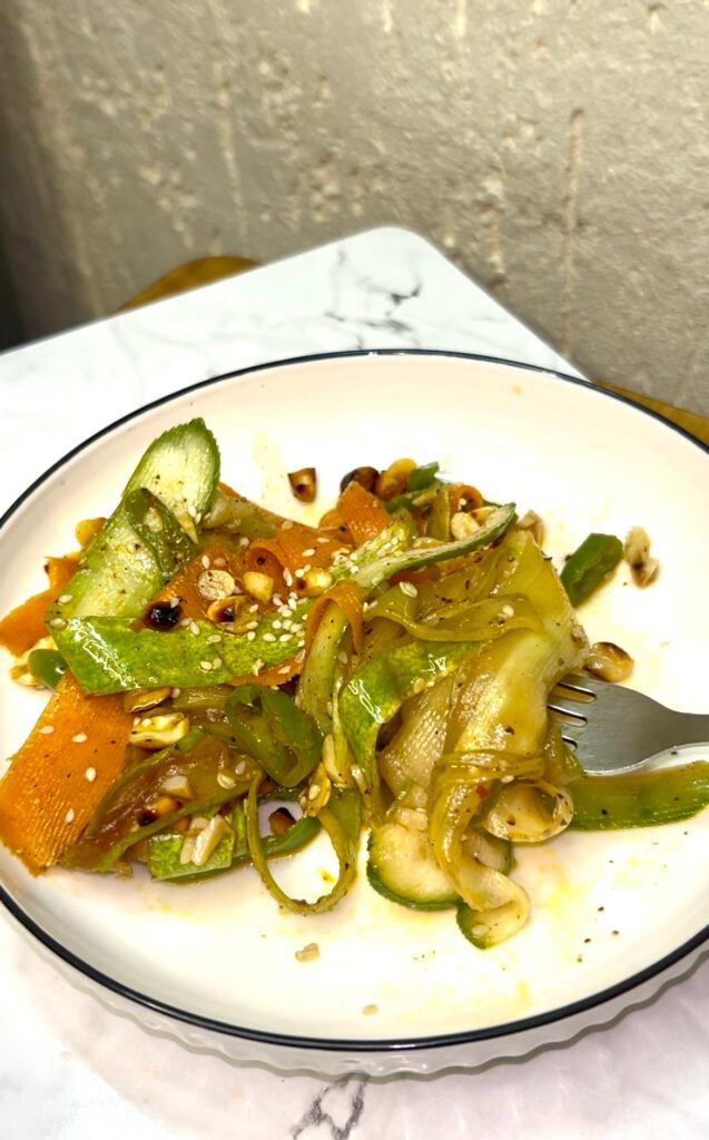 Colorful cucumber noodle salad served in a ceramic bowl with chopsticks