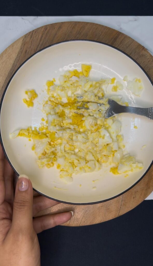 Four variations of scrambled egg toast served on a wooden board