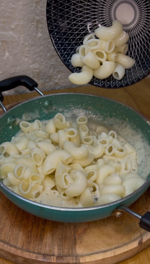 Freshly baked mac and cheese with breadcrumb crust on a wooden table