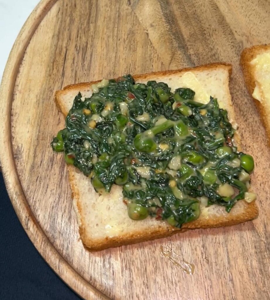 Close-up of spinach toast with bubbling cheese fresh from the oven