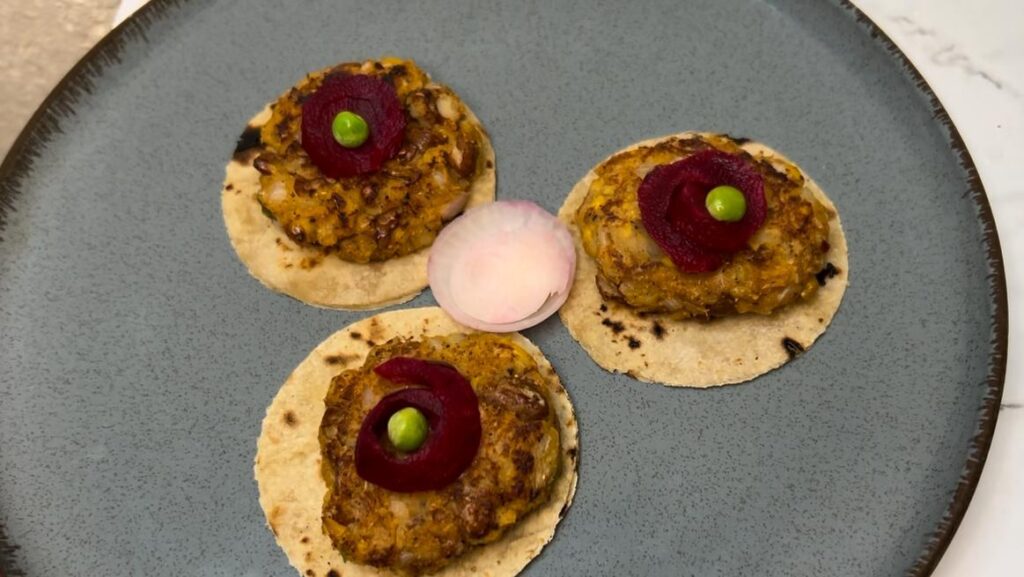 Tacos filled with mixed beans, veggies, and guacamole on a plate