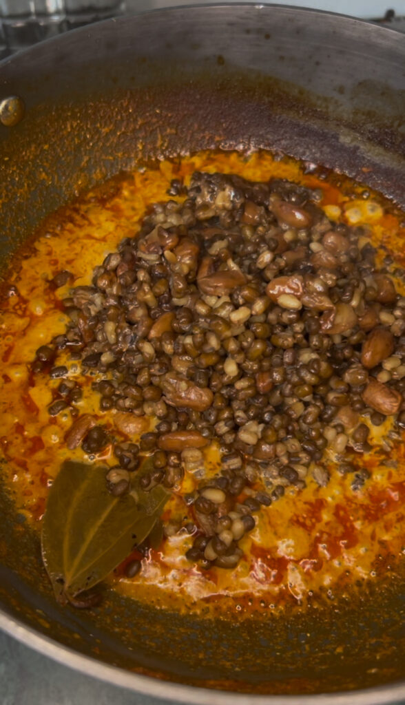 Close-up of a simmering black lentil stew in a pot