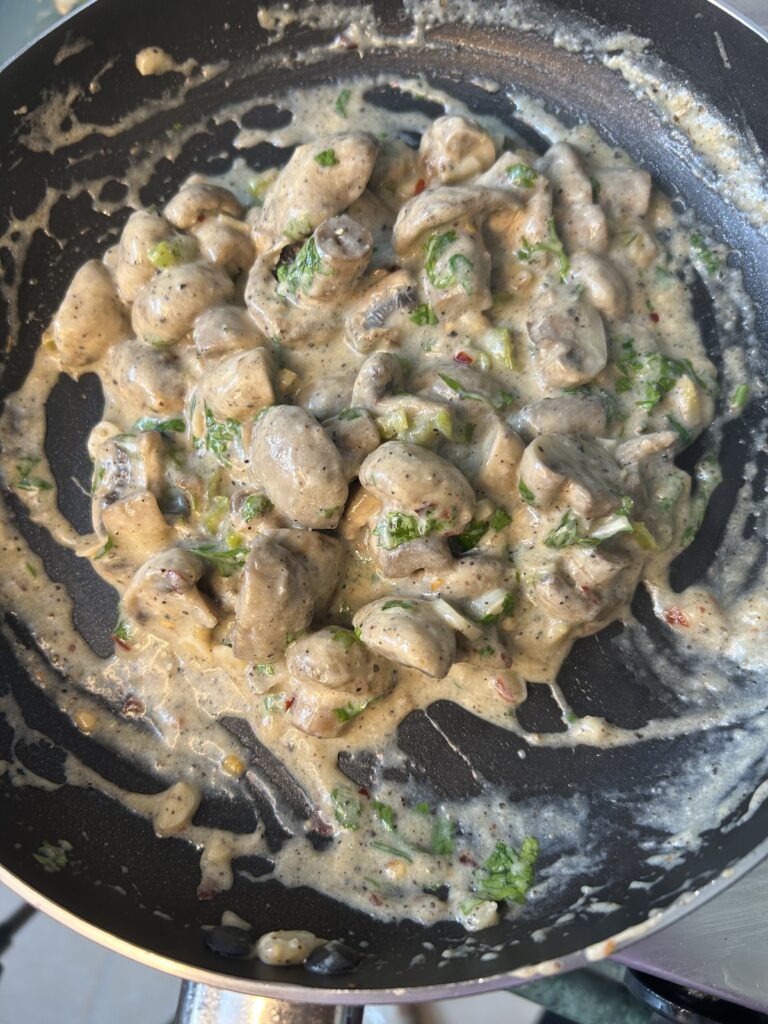 Rustic wooden table with creamy mushroom dish and a side of salad