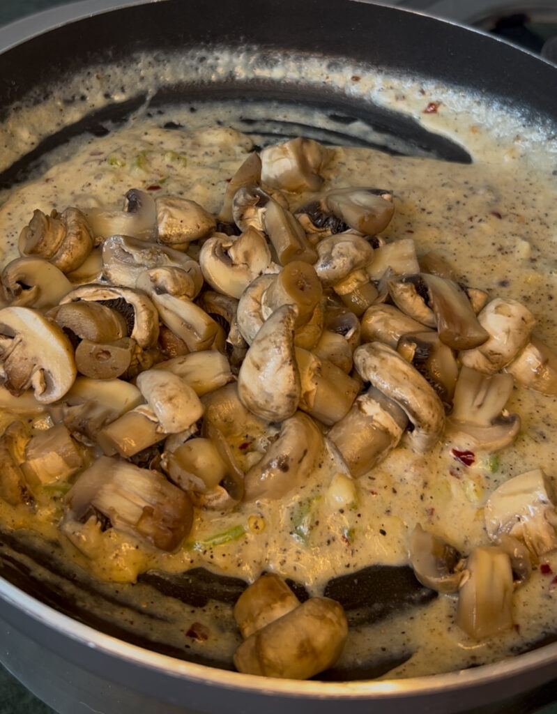 Rustic wooden table with creamy mushroom dish and a side of salad