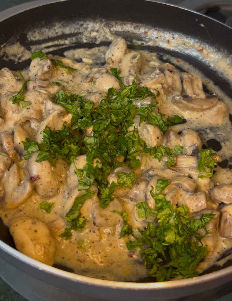 Rustic wooden table with creamy mushroom dish and a side of salad