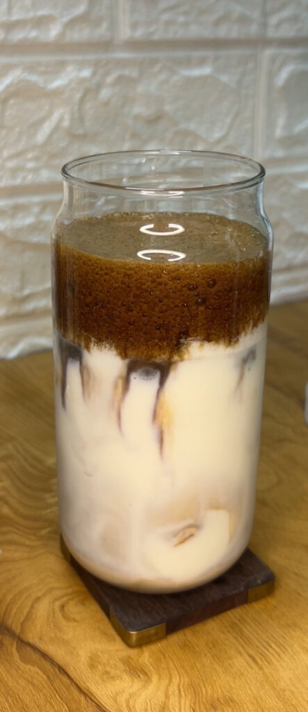 Biscoff latte with whipped cream in a glass mug