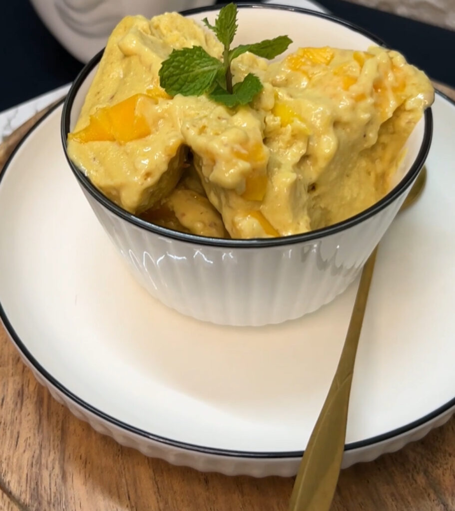 Homemade mango ice cream served in a bowl with fresh mango slices