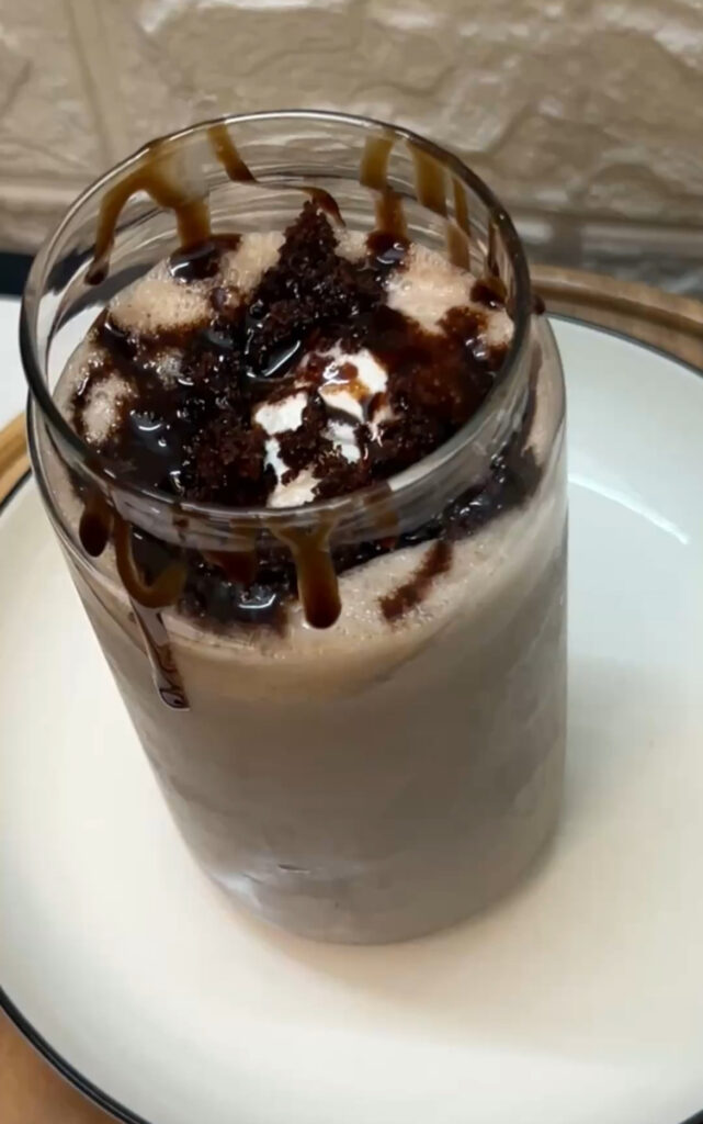 Refreshing homemade brownie milkshake topped with whipped cream


