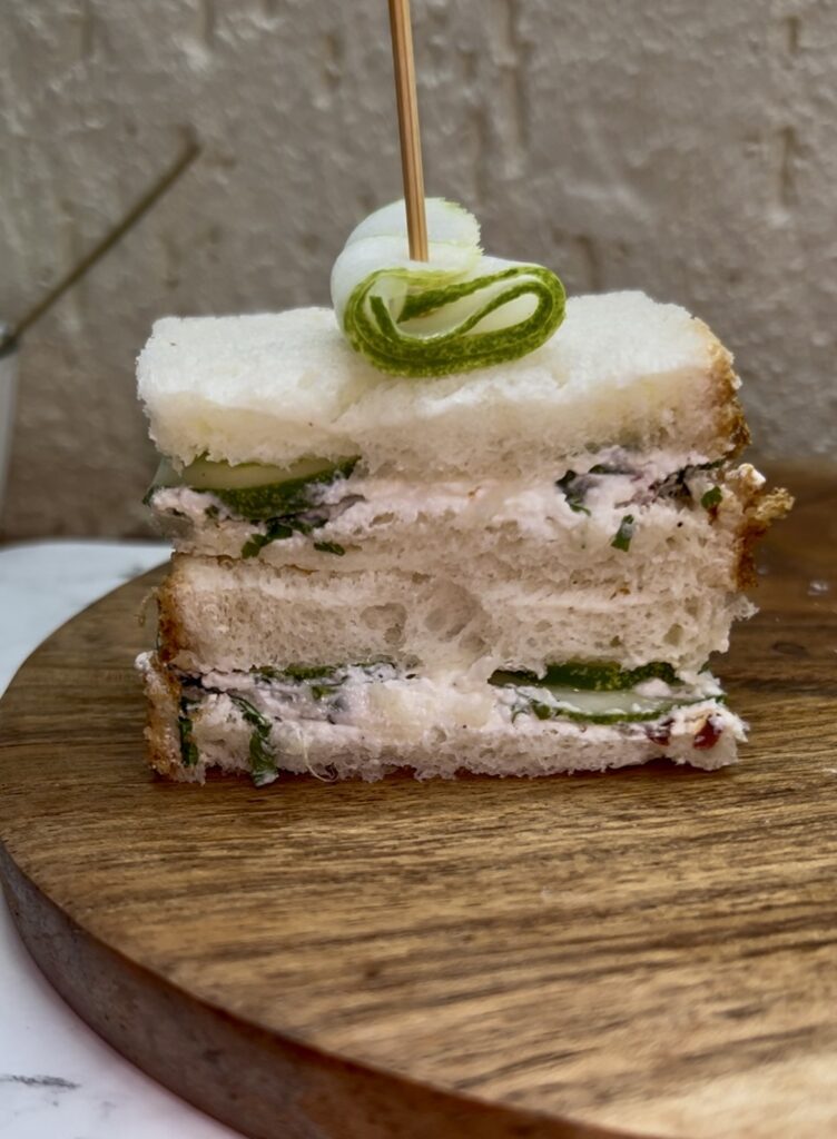 Fresh cucumber sandwich on whole wheat bread served with herbs