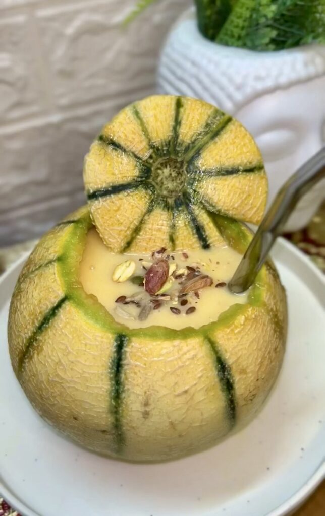 Glass of refreshing muskmelon smoothie topped with mint leaves