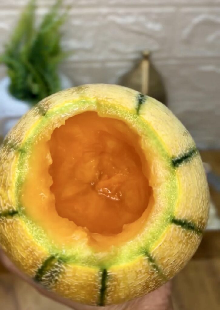 Healthy muskmelon smoothie in a mason jar with striped straw