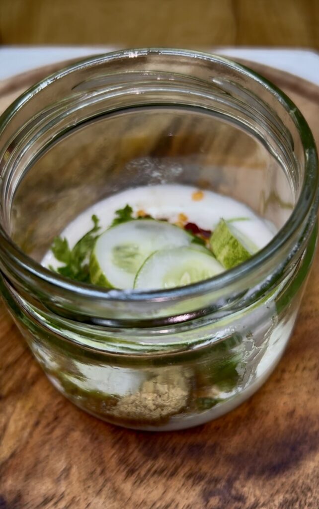 Homemade creamy cucumber salad garnished with parsley and onion