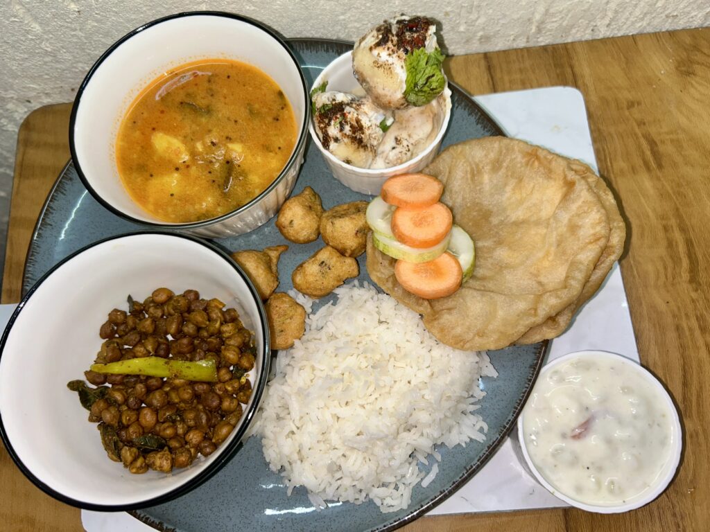 Colorful vegetarian platter with fresh veggies, dips, and bread