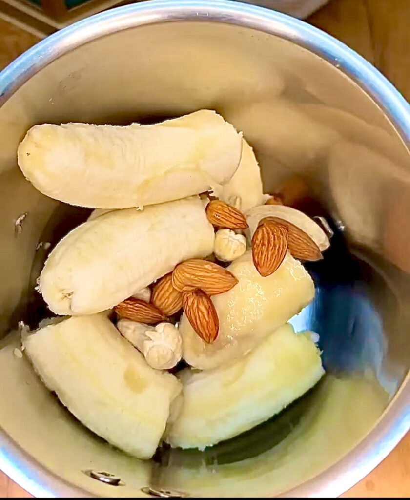 Creamy banana milkshake in a tall glass with a straw