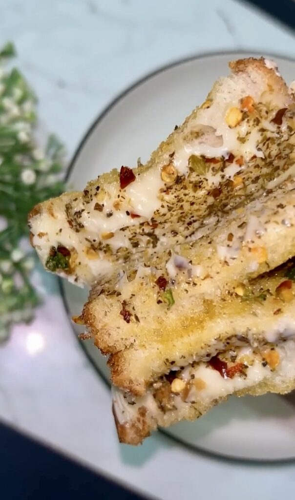 Freshly toasted garlic sandwich served on a wooden plate