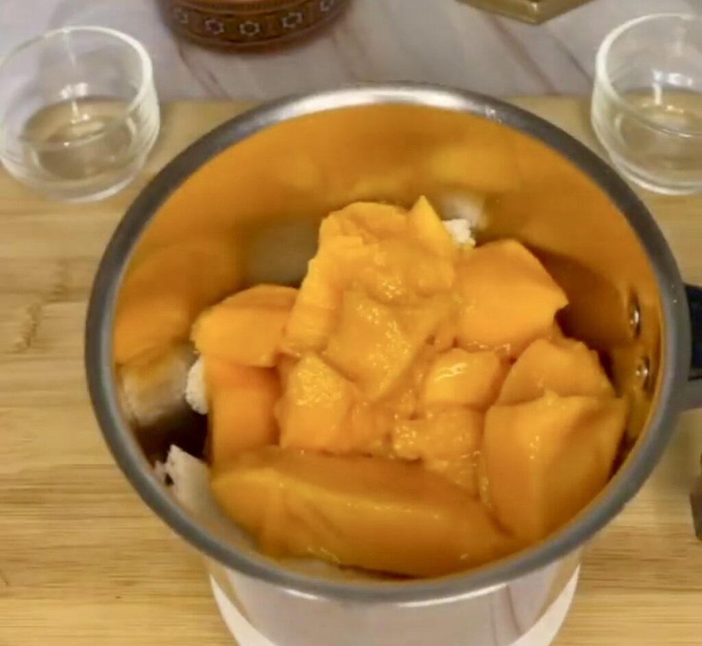 Homemade mango pudding topped with whipped cream and mint leaves